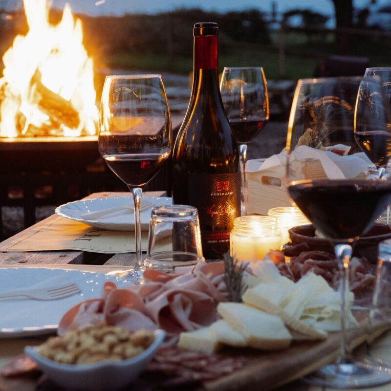 Calici con tagliere e dietro un barciere durante l'aperivino