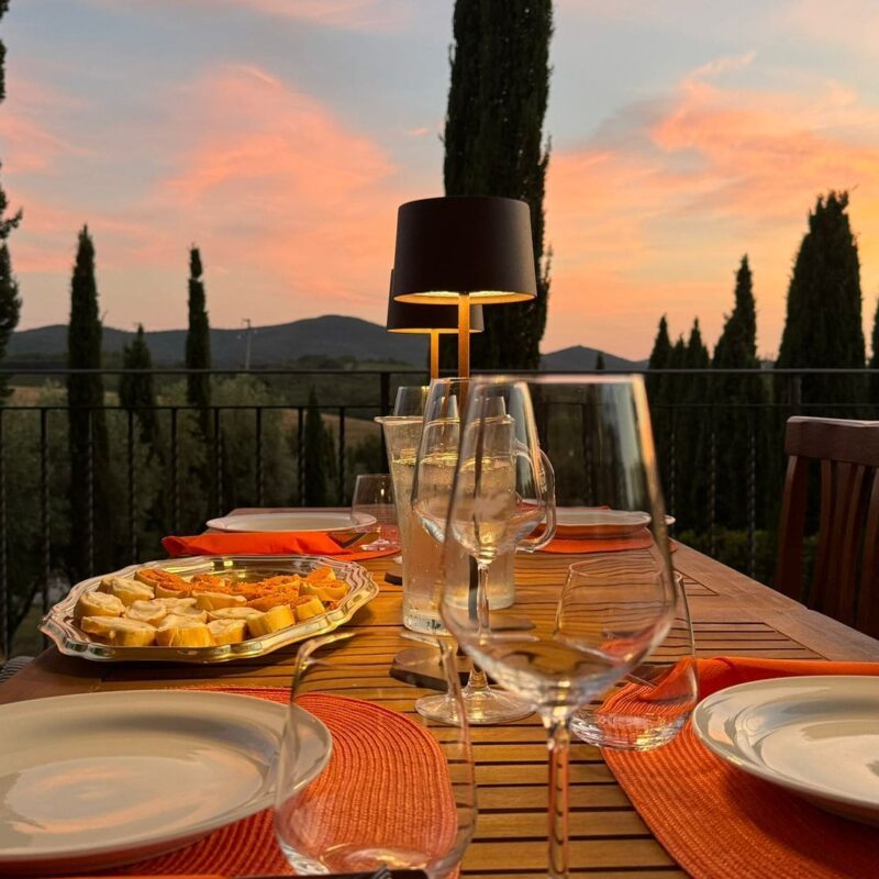 Tavola in terrazza panoramica apparecchiata per cena tosco siriana