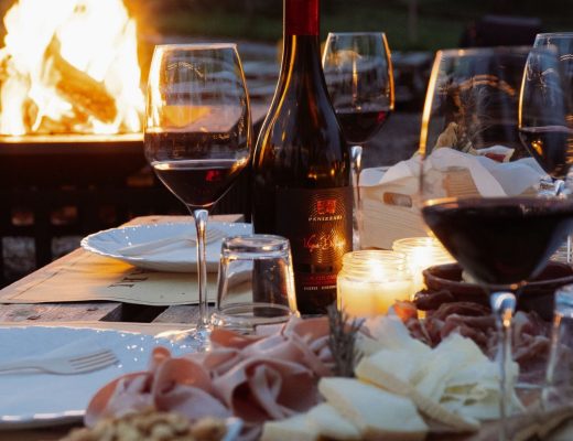 Calici con tagliere e dietro un barciere durante l'aperivino