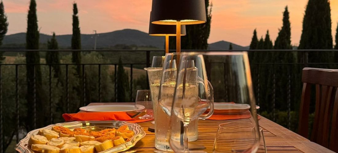 Tavola in terrazza panoramica apparecchiata per cena tosco siriana