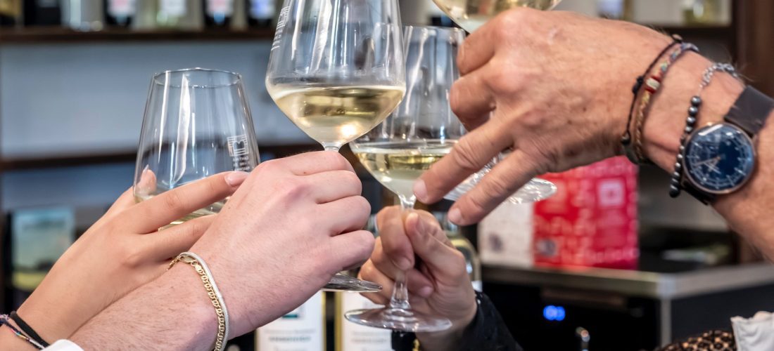 Persone che fan brindisi con vino bianco della Maremma Toscana