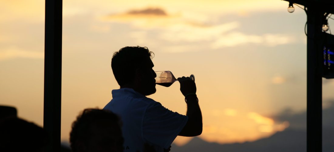 ragazzo che degusta calice di vino al tramonto in Alto Piemonte