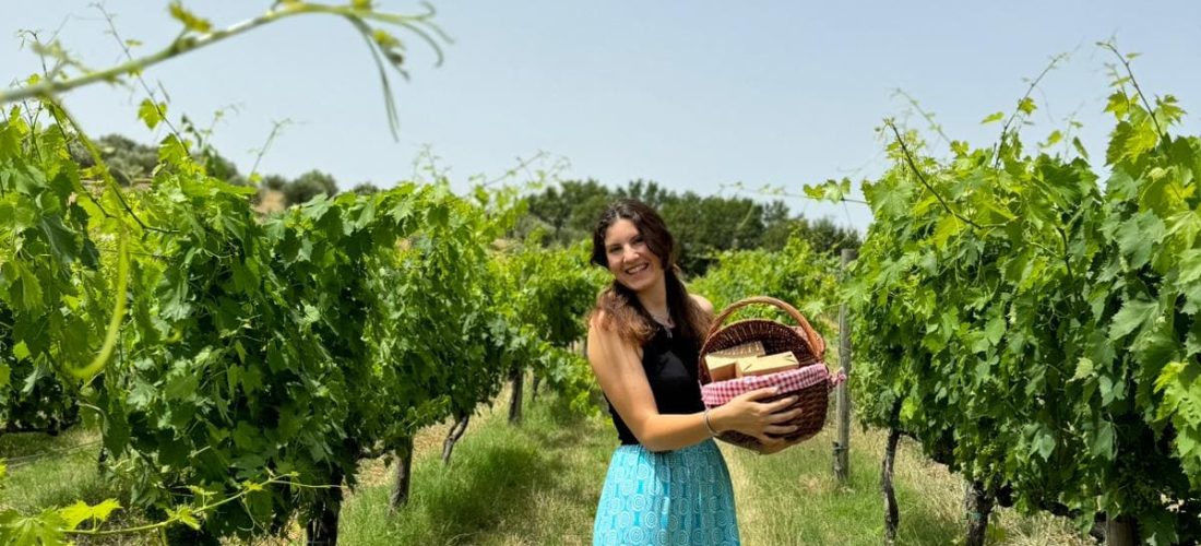 Ragazza con in mano un cestino da picnic tra i vigneti di Montepulciano